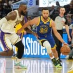 Dec 25, 2024; San Francisco, California, USA; Golden State Warriors guard Stephen Curry (30) dribbles against Los Angeles Lakers forward LeBron James (left) during the third quarter at Chase Center. Mandatory Credit: Darren Yamashita-Imagn Images