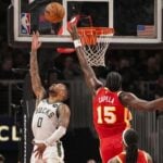 Milwaukee Bucks guard Damian Lillard (0) lays in a basket behind Atlanta Hawks center Clint Capela (15)